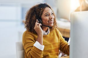 Answering service professional woman with her hand on her headset.